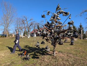 Vyras juodais drabužiais ir akiniais.